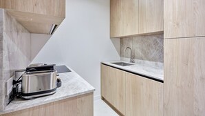 A compact kitchen with a built-in toaster, a sink, and wooden cabinets. - Sublime Flat in the Centre of Paris-montorgueil (Paris)