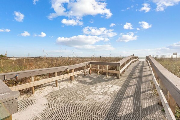Un muelle de madera que conduce a una playa con cielo despejado.