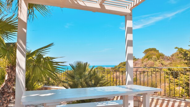 A white wooden bench under a white pergola with a clear view of the ocean and surrounding vegetation. - Relax in Villa with Pool 150mt from the Sea 8 Beds "OA" (Alcamo Marina, Sicilia, Italia)