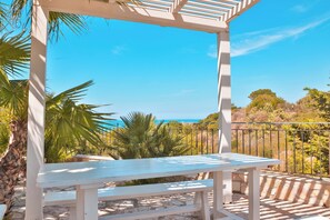 A white wooden bench under a white pergola with a clear view of the ocean and surrounding vegetation. - Relax in Villa with Pool 150mt from the Sea 8 Beds "OA" (Alcamo Marina, Sicilia, Italia)