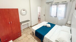 A bedroom with a bed, a red wardrobe, a small desk, and a bathroom visible through an open door. - Relax in Villa with Pool 150mt from the Sea 8 Beds "OA" (Alcamo Marina, Sicilia, Italia)
