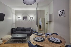 Relax in a welcoming space with a comfortable sofa, dining area, and large mirror.