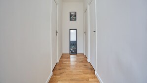 A hallway with wooden flooring and white walls. - Superb Atypical Apartment Paris Center Le Marais (Paris)