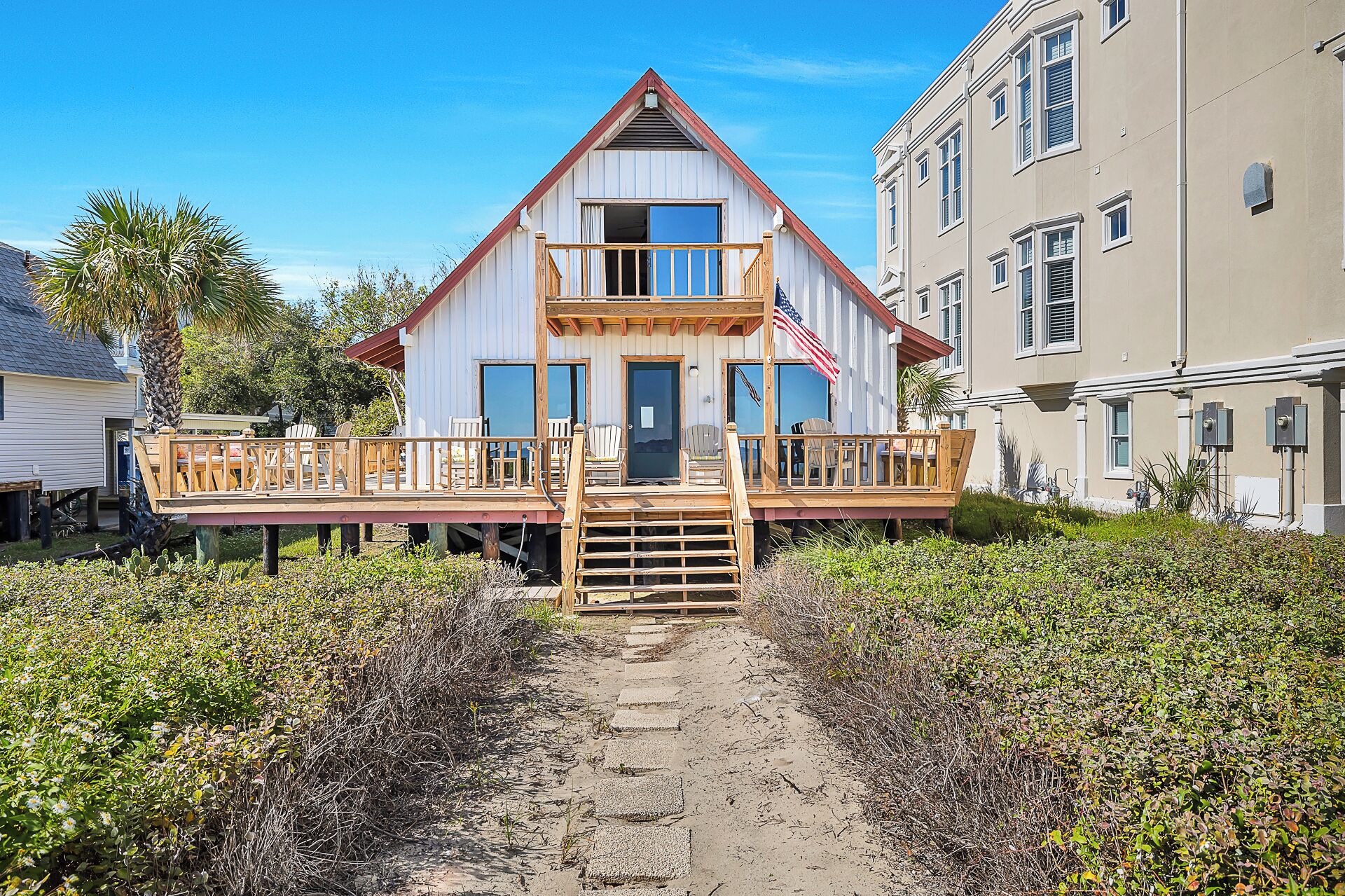 A two-story house with a wooden deck and a front porch.