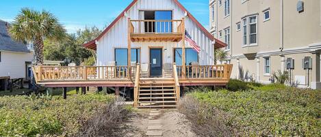 A two-story house with a wooden deck and a front porch.