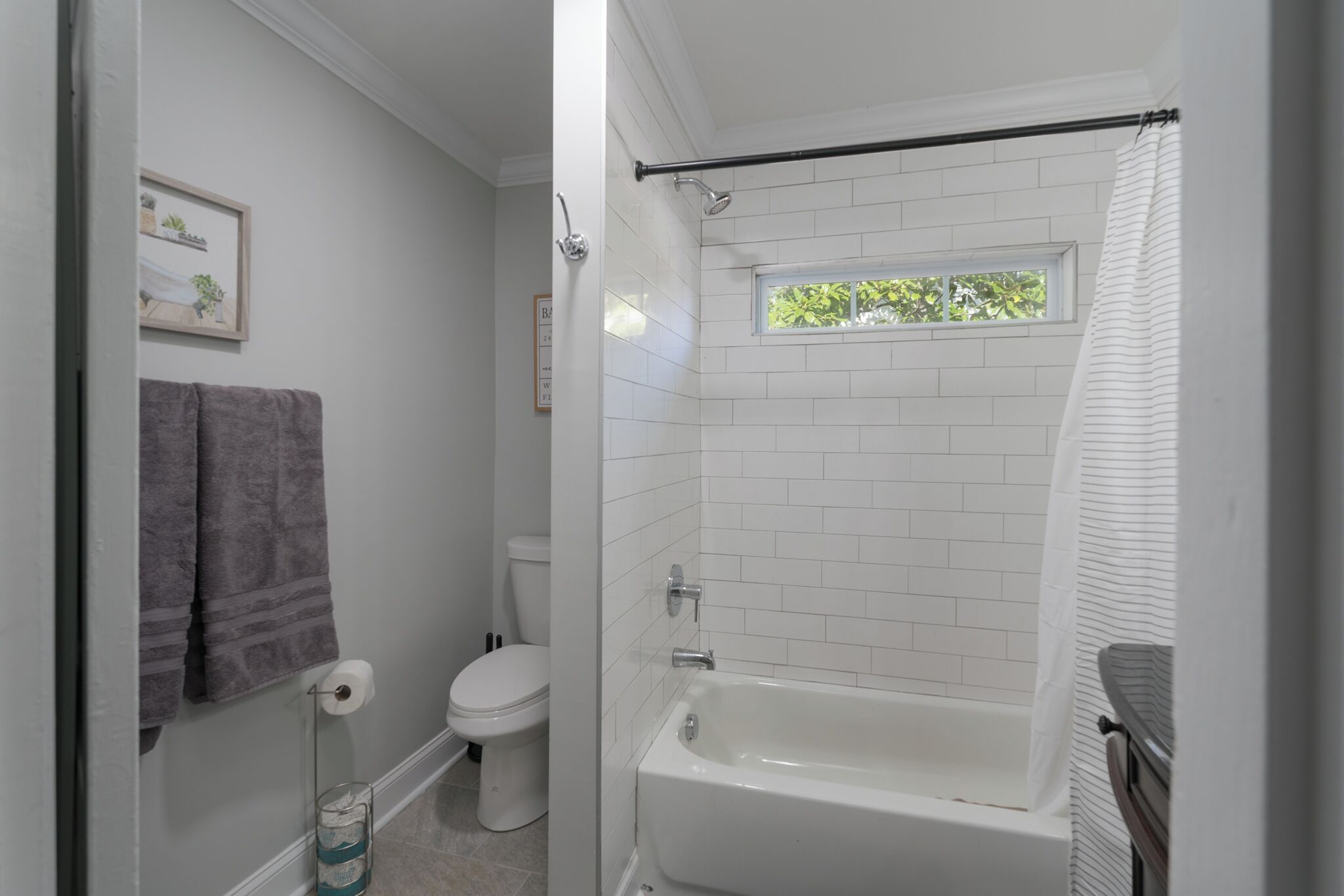 Un baño con bañera, inodoro y ventana.
