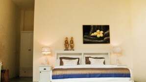 A bedroom with a bed, nightstands, a ceiling fan, and a wall-mounted picture.