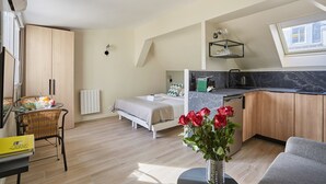 A compact living space with a kitchenette, a dining area, and a bedroom. - Charming Studio Paris Center / Bourse (Paris)