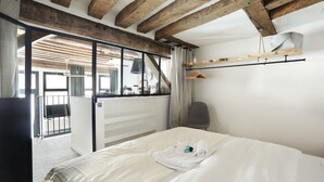 Una camera d'albergo con un letto, una sedia, un appendiabiti e vista all'esterno.