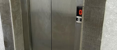 A metallic elevator with a digital display showing '0'.