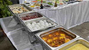 Una mesa de buffet con diferentes opciones de comida, como arroz, albóndigas y un plato de curry.