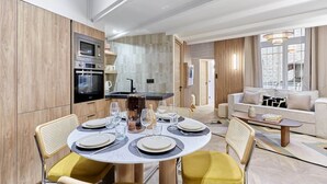 Un soggiorno moderno con un tavolo rotondo da pranzo per quattro persone, un divano e un tavolino.