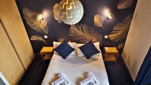 Una camera d'albergo con un letto grande, due comodini e decorazioni a parete.