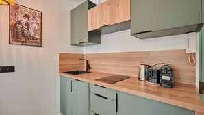 Une cuisine moderne avec un plan de travail en bois, un évier et une bouilloire.