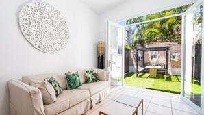 Un soggiorno moderno con un divano beige, un tavolino e un elemento decorativo a parete.