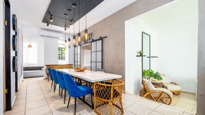 Un'area pranzo moderna con un tavolo bianco, sedie blu e sedie in vimini.