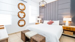 Una camera da letto moderna con un letto grande, comodini, una scrivania e specchi decorativi a parete.