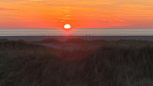 A sunset over a beach with a clear sky and calm sea. - Meeresbrise 1 Top location with garden use. Pet friendly! (Tönning)