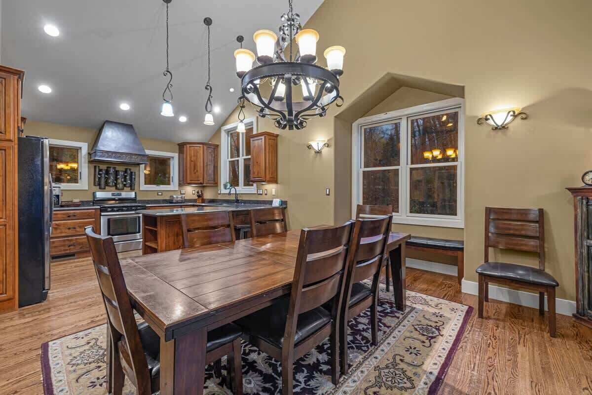 A spacious kitchen with wooden cabinets, a large island, and a chandelier.