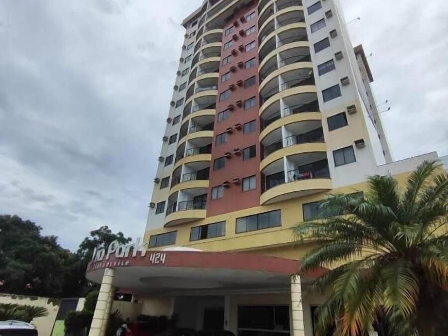 Un hotel de varios pisos con fachada curva, número 424, y un estacionamiento al frente.