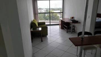 Apartamento básico, vista para a cidade | Área de estar | Smart TV 32 polegadas com canais via satélite