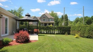 A residential backyard with a gazebo, a well-maintained lawn, and a house in the background. - Beautiful home for you (Sherbrooke)
