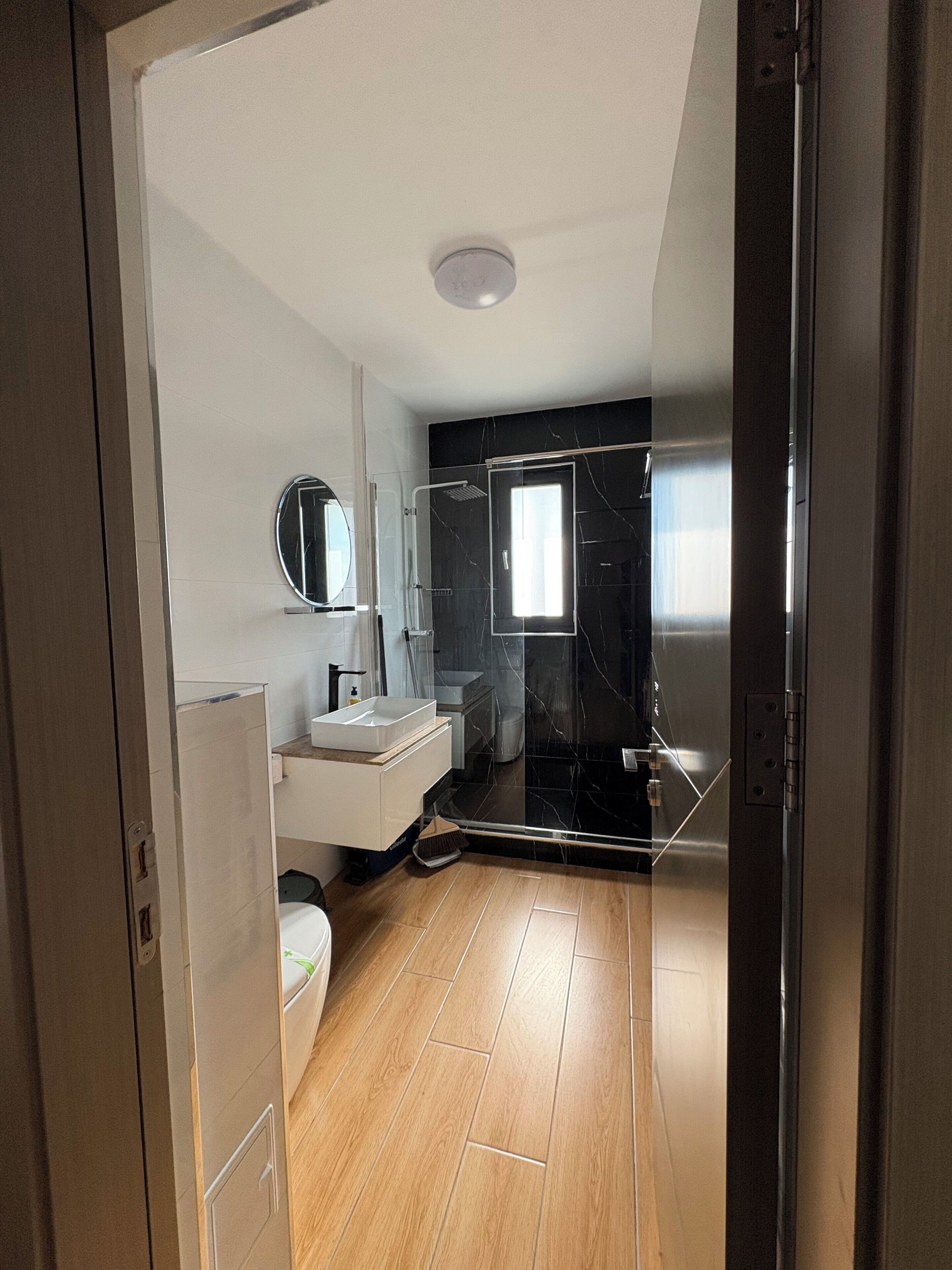 Une salle de bain moderne équipée d’une douche, de toilettes et d’un lavabo.