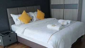 Un dormitorio moderno con cama, mesita de noche, armario y un cuadro en la pared.