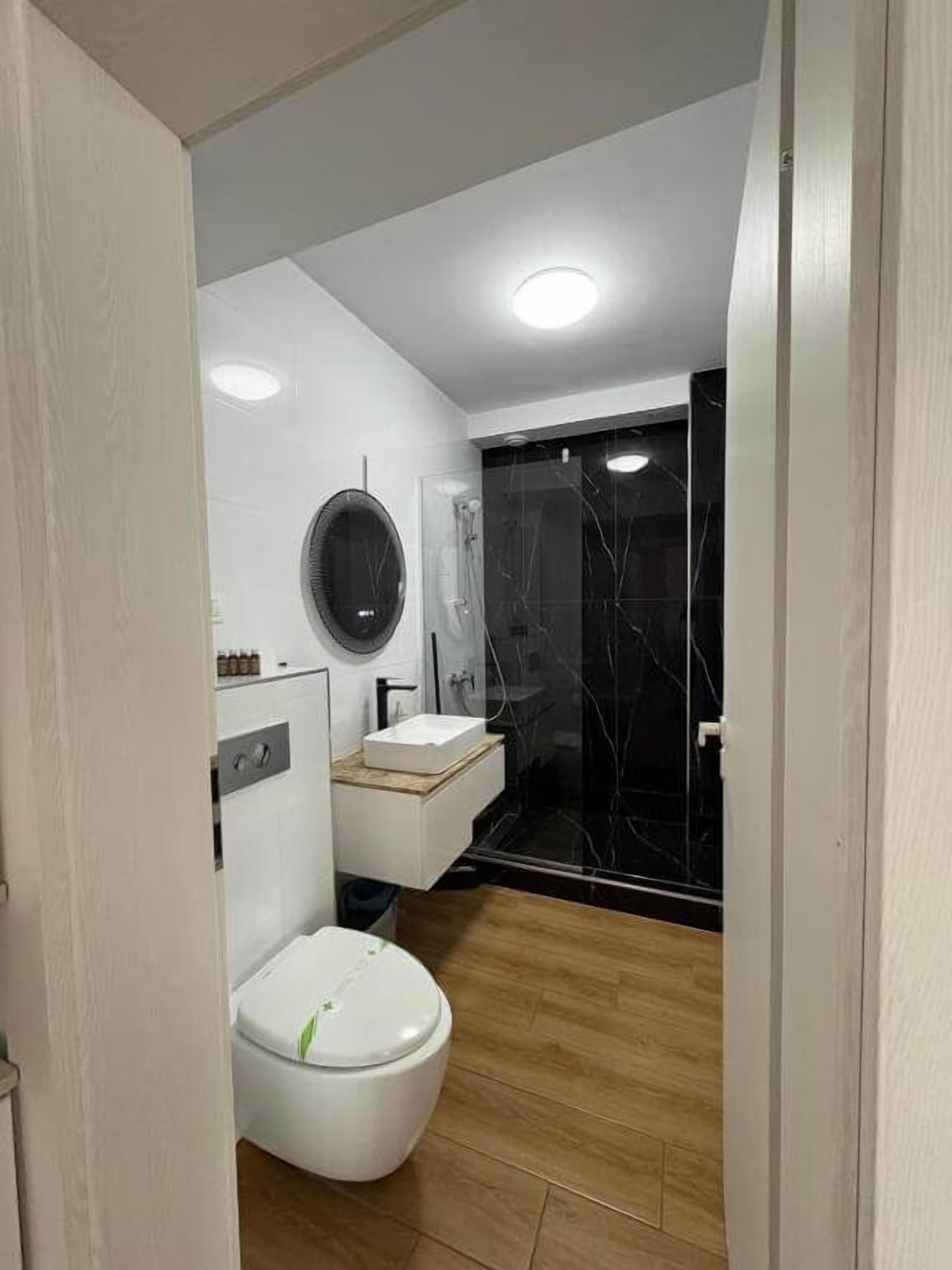 A modern bathroom with a toilet, sink, and shower.