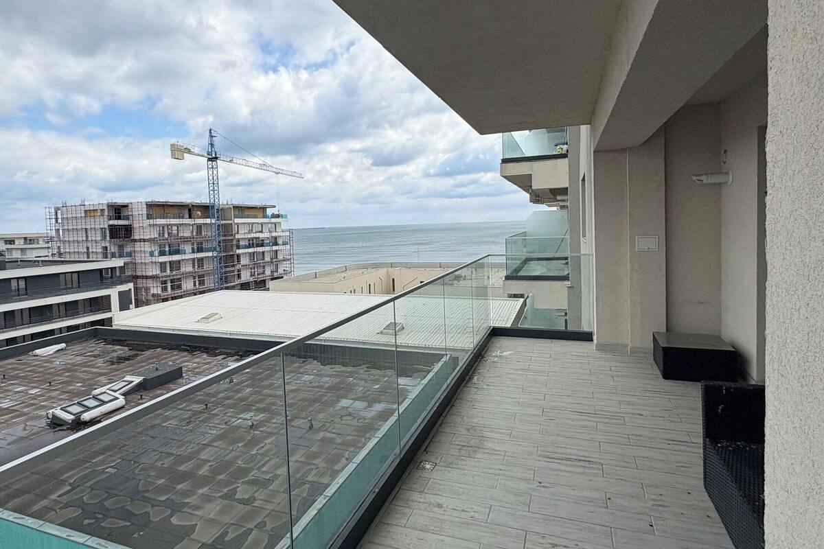 Une terrasse sur le toit offrant une vue sur la plage et sur un chantier de construction en arrière-plan.