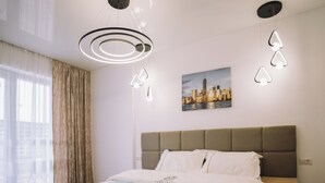 A hotel room with a large bed, a headboard, a nightstand, and a wall-mounted picture. - Signature Promenada Hotel-Apartments 2 (Navodari)
