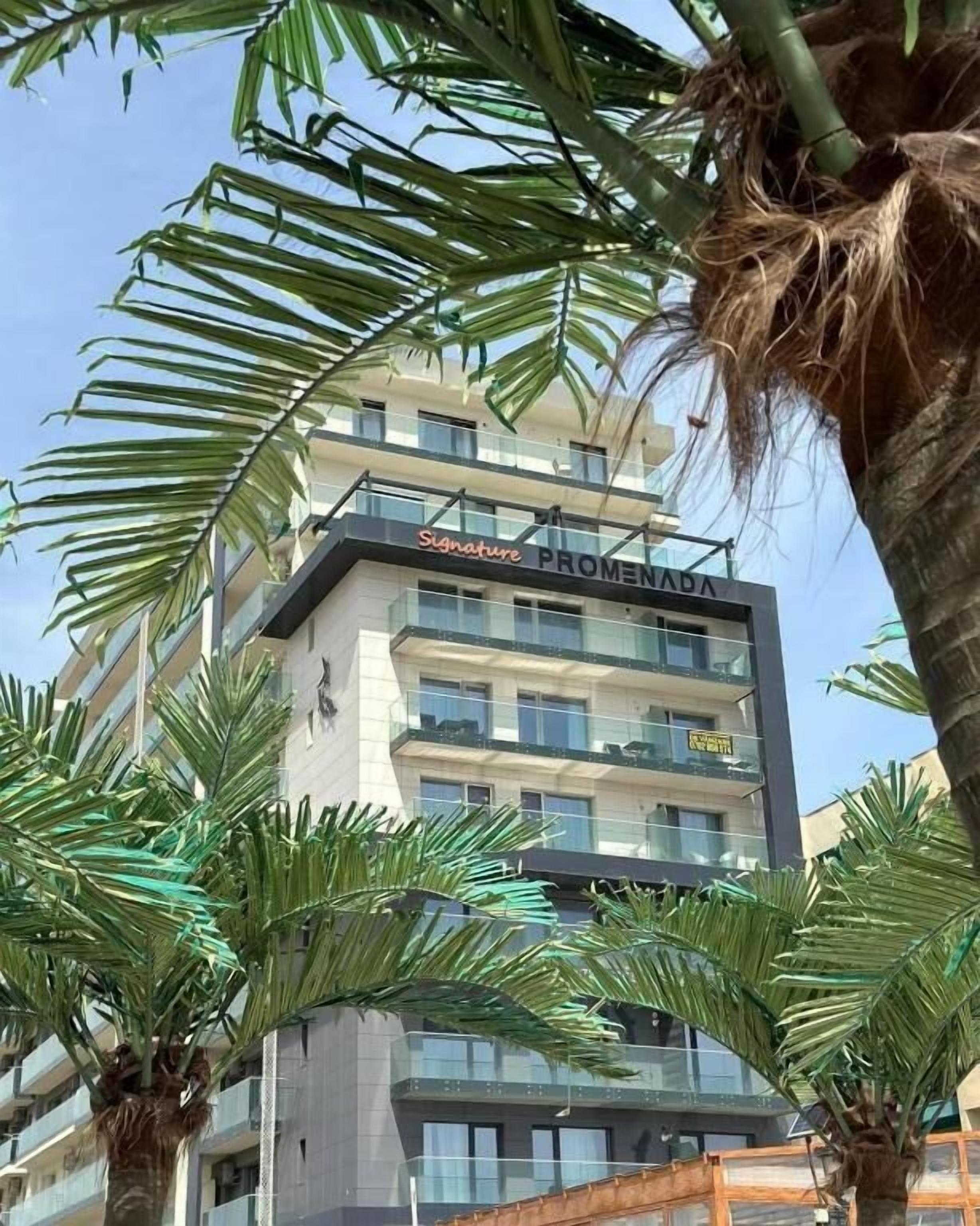 A multi-story hotel named "Signature PROMENA" with balconies and a modern architectural design.