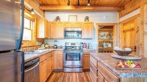 Una cocina moderna con armarios de madera, electrodomésticos de acero inoxidable y encimera de granito.