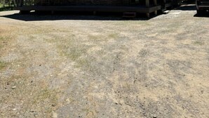 Eine zweistöckige Blockhütte mit Satteldach, einer Veranda und einem Schotterweg.