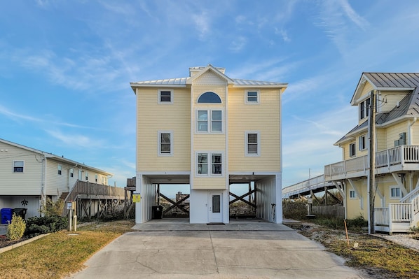 Stunning two-story building with a central entrance and arched window, set amidst a beautifully manicured lawn.