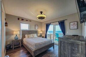 Cozy retreat with a large bed, ceiling fan, and wooden nightstand.