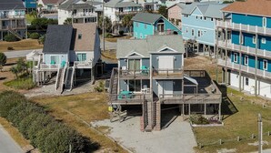 A beachfront property with multiple levels, including a main house and several smaller structures, likely guest houses or cottages. - Buccaneers Bounty II: Enjoy Stunning Ocean Views (North Topsail Beach)