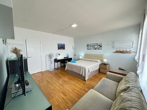 Cozy retreat with a neatly made bed, desk, and comfortable seating area.