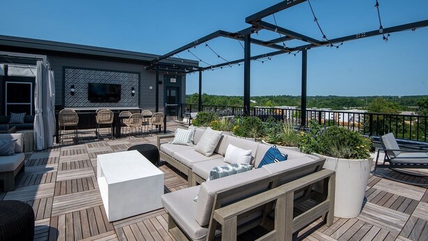 Una terraza al aire libre con un sofá, sillas y una mesa.