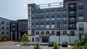 Un edificio de varios pisos con un llamativo letrero de 'VIRIDIUM' en la fachada.