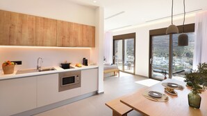 Une cuisine moderne équipée d’un four encastré, d’un évier et d’un meuble en bois.