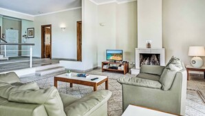 Ein Wohnzimmer mit Kamin, Fernseher und einer Couch.