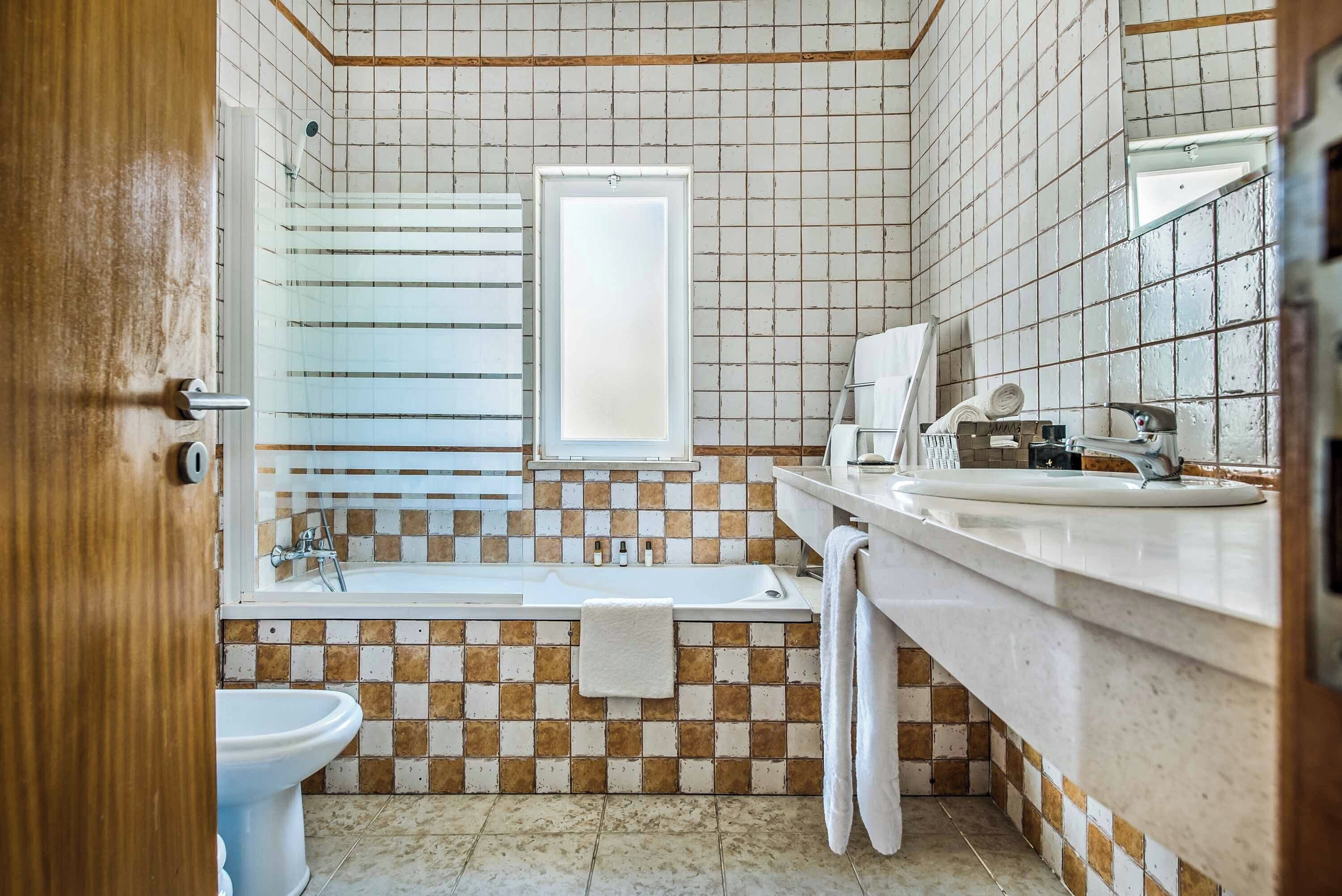 Un bagno con vasca, WC e lavandino.