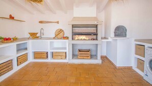 A kitchen with a built-in oven, wooden storage, and hanging baskets. - Brisa y Mar - Six Bedroom Villa, Sleeps 12 (Calp)