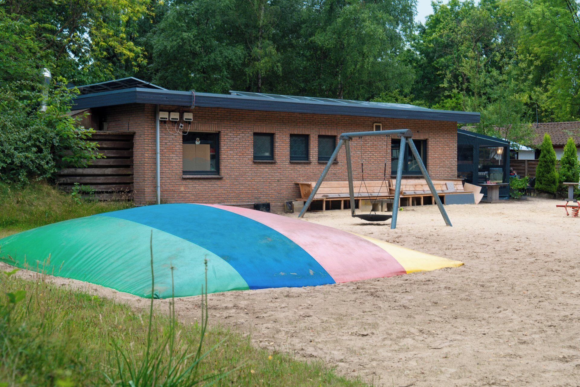 A building with a brick exterior and a swing set in front.