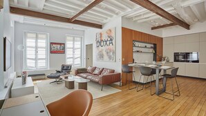 A modern living room with a sofa, coffee table, and dining area. - Amazing 2 Bedrooms Apartement Paris Center (Paris)