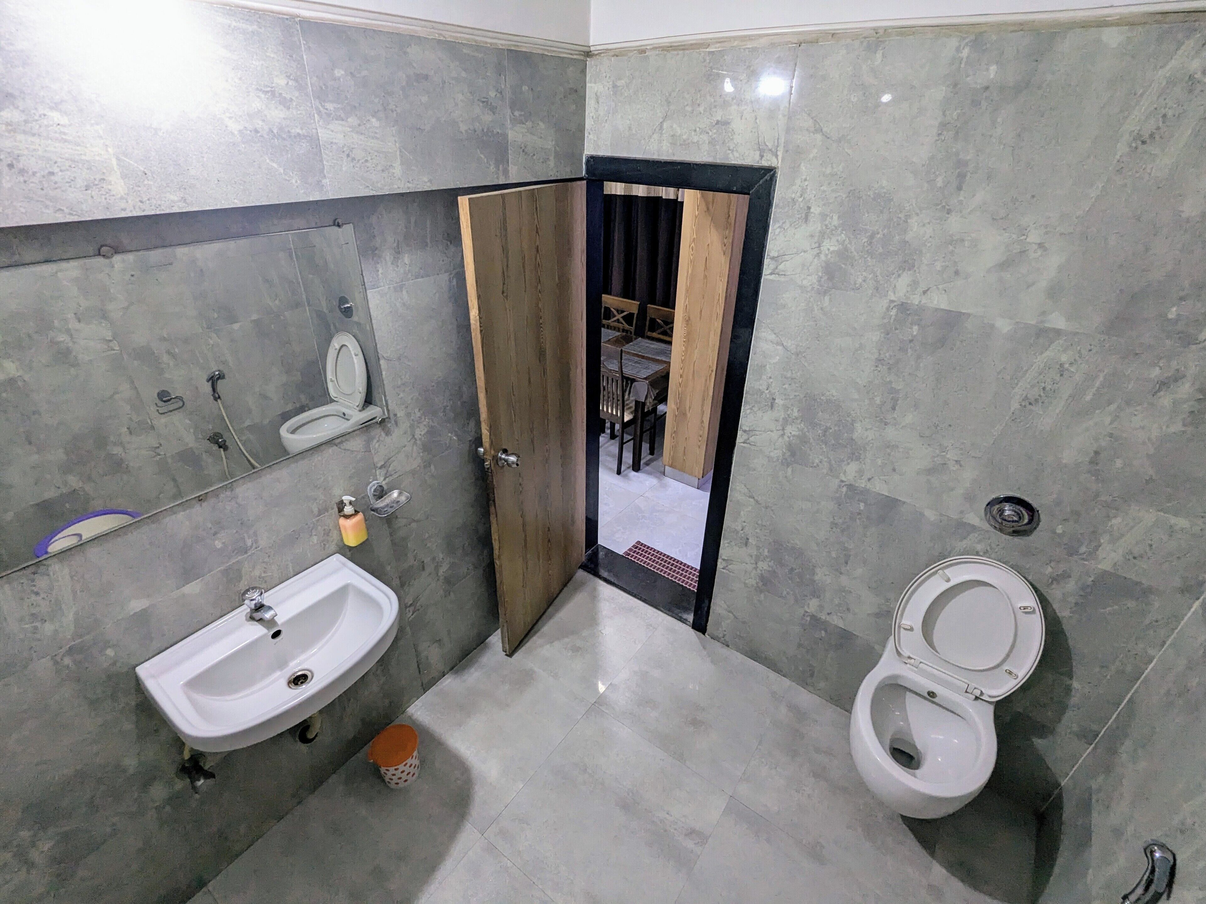 A bathroom with a sink, toilet, and a mirror.