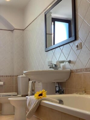 A bathroom with a sink, toilet, and bathtub. - B&B CASABELLA (Riposto)