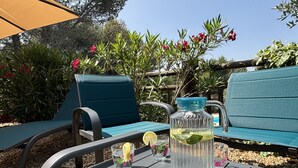 Ein Tisch mit einer klaren Karaffe, zwei Gläsern mit Zitronenscheiben und einer Tasse mit Blumenmuster.
