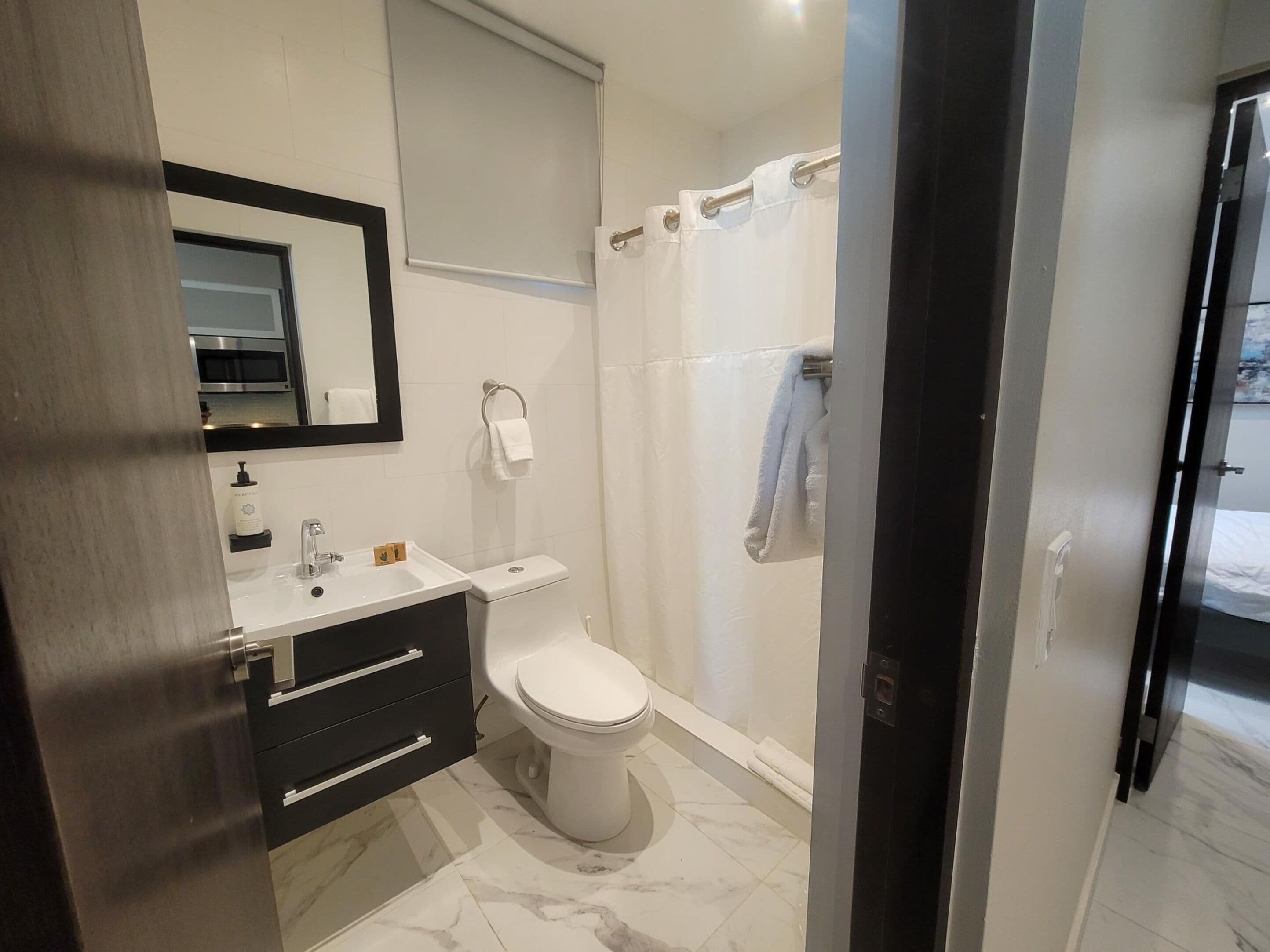 A modern bathroom with a toilet, sink, and shower.